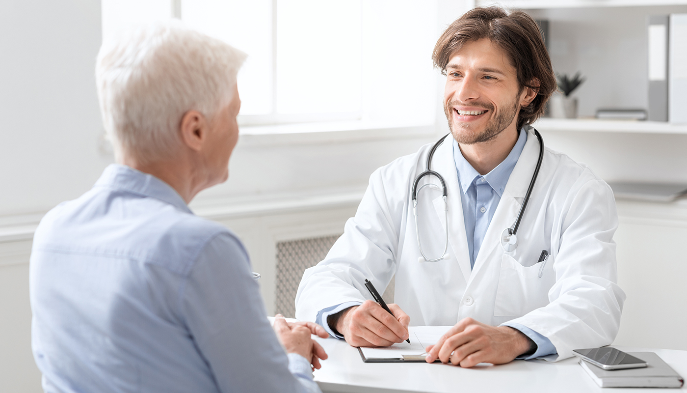 A doctor sitting at the table with an older man.